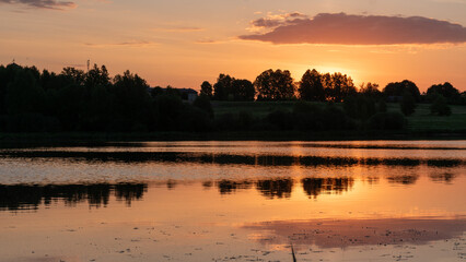 Naklejka premium colorful sunrise, sunset landscape by the lake, brightly colored sky is reflected in the water of the lake