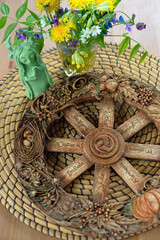 wheel of the year with flowers and Shaman, forest spirit figurine on table close up. wiccan Altar for witchcraft. Symbol of wiccan sabbat. esoteric spiritual ritual, magic. 