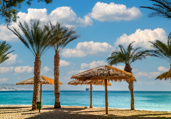 Morning on sandy beach of the Red Sea in Eilat - famous tourist resort and recreational city in Israel. Concept of bliss vacation and happy holiday  