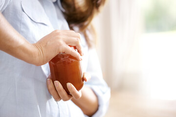 Person, struggle and hands with jar of jam, open and organic for nutritionist, kitchen and house....