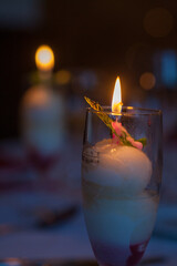 Imagine a glowing candle positioned on glass, creating a cozy and intimate atmosphere with its warm...