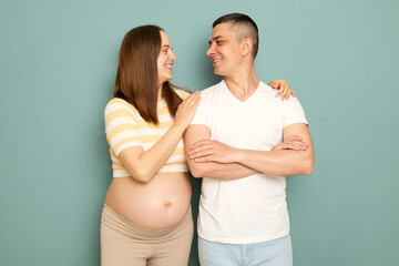 Loving smiling cheerful young couple expecting baby standing together expressing love expecting...