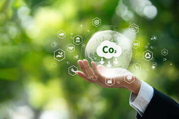 Net zero carbon emission for carbon credit, carbon footprint concept to development sustainable environment. icon co2 and earth on businessman hand for save world carbon neutral.