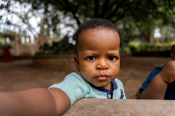 Cute african boy taking selfie sitting in the garden