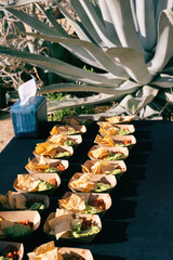 Chips, salsa and guacamole served in paper trays at an outdoor event
