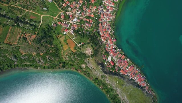 Albanian Village's Stunning Lakeside Presence: A Natural Haven on the Rocky Peninsula with Emerald Waters, Offering Scenic Protection