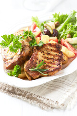 Grilled Steaks with french fries and fresh salad. Bright wooden background.
