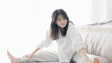寝室でストレッチをする女性