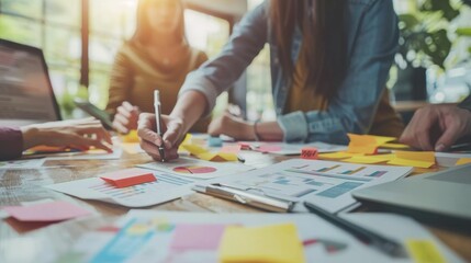 E-commerce team brainstorming new sales strategies. Creative team brainstorming with sticky notes and charts in a modern office setting, collaborating on a business project.