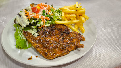 Spicy Mala Pork Neck Steak ,pork loin, pork shoulder, well-cooked spicy sauce. salad side dishes eaten raw, green oak vegetables, corn with creamy salad dressing and local style French fries