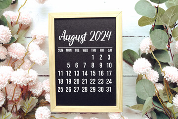 August 2024 monthly calendar with flower bouquet decoration on wooden background