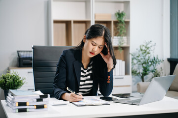 Woman who is tired and overthinking from working with tablet and laptop at modern office..