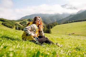 Woman tourist traveler walking on field, top of mountain in summer sunny day under sun light. Travel, nature concept.