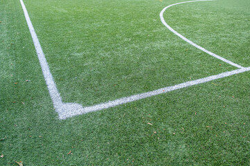 green synthetic grass surface on a soccer ground. European football field, artificial grass. Corner detail
