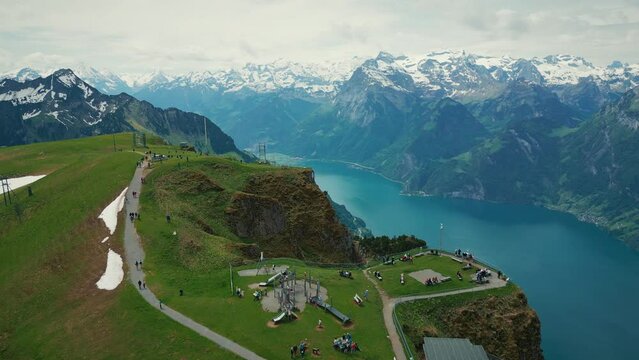 Fronalpstock with snowy rocky Swiss Alps mountains and lake on horizon, Stoos.
