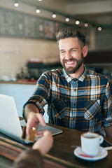 Fototapeta premium Credit card, coffee shop and man with laptop, paying or search internet with connection, thinking or social media. Creative guy, freelancer or copywriting with technology, graphic designer and cafe