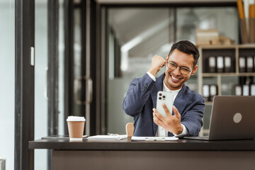 Middle-aged Asian businessman in formal suit working diligently at his desk. seasoned business and investment consultant, specializing in strategic portfolio management and financial analysis.