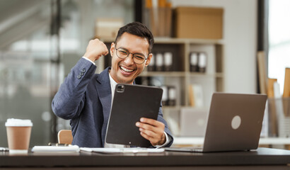 Middle-aged Asian businessman in formal suit working diligently at his desk. seasoned business and investment consultant, specializing in strategic portfolio management and financial analysis.