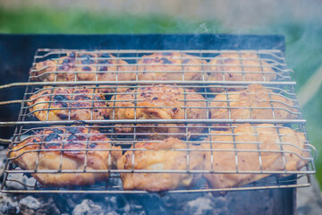 A chicken is being cooked on a grill, creating smoky flavors