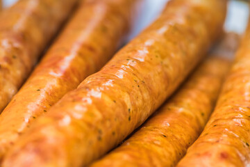 A close up of three sausages on a table. Delicious sausages cooked over a fire