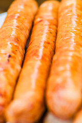A close up of three sausages on a table. Delicious sausages cooked over a fire
