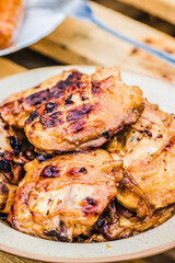 Grilled chicken thighs placed on a plate, captured in close up