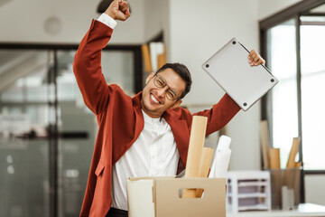 A middle-aged Asian businessman in a formal suit is working at his desk, preparing to resign after...
