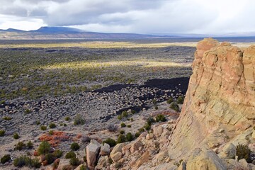 
looking out from the sandstone bluffs overlooks at lava fields in el malpais national monument,...