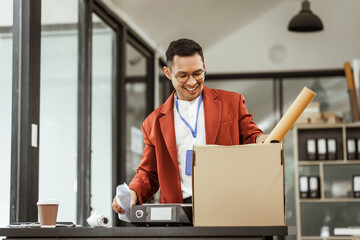 A middle-aged Asian businessman in a formal suit is working at his desk, preparing to resign after...