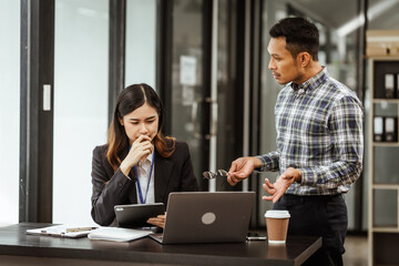 Young businesswoman and other Asian individuals are seen working at desks. Accountability,...