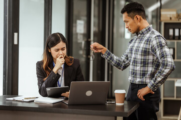 Young businesswoman and other Asian individuals are seen working at desks. Accountability,...