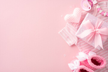 Assorted pink baby shower gifts and accessories, including a heart, pacifier, and baby clothes on a pastel background
