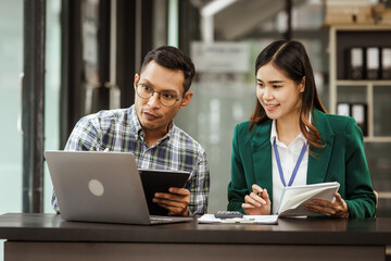 A middle-aged businessman, a young businesswoman, and Asian individuals are collaborating at desks. They engage in teamwork while managing commodities, trade, finance, and talent acquisition.