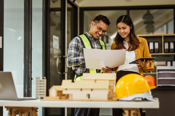 A middle-aged man, a young woman, and other Asian individuals collaborate on architectural engineering for condos and apartments, focusing on sustainable renovation and green energy solutions.