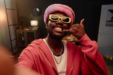 POV portrait of African American man filming viral dance video and wearing pink outfit