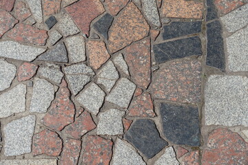 Multicolored crazy pavement made of polished granite stone blocks