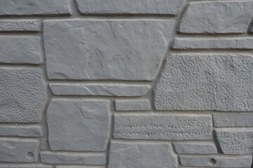 Close up of dark gray concrete brick veneer wall with random layout
