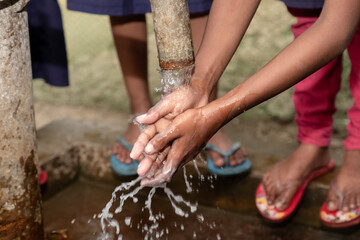 Children washing their hands at an outdoor water tap. Keep your hands clean. current affairs 2020....