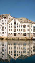 View of the charming architecture of a building in the Norwegian town known for its Art Nouveau architectural style, waterfront residences facing the Brosundet canal, Alesund, Norway