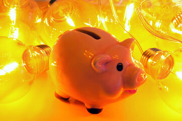 Concept de dépenses d'électricité avec une tirelire et une guirlande d'ampoules électriques sur...