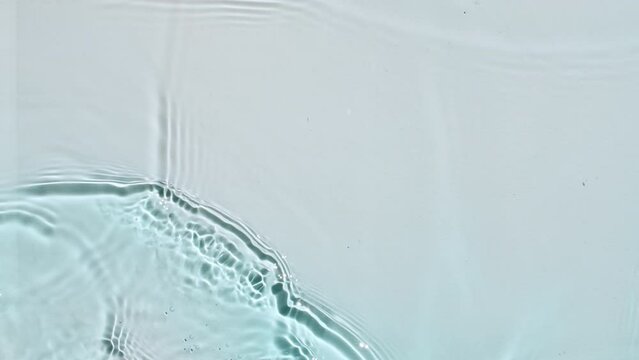 Water surface texture top view. Water waves blue colored. Sun and shadows. Pure blue water with reflections sunlight in slow motion. Motion clean swimming pool ripples and wave. 4k. High quality 