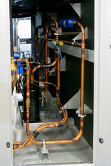 The compressor of the refrigerator with copper pipes.