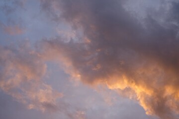 Clouds painted orange by the setting sun in the evening sky.                           