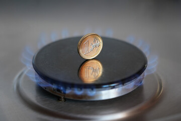 Gas stove with coins in flame. Concept image of rising price. The European Union and Poland are struggling with rising gas prices