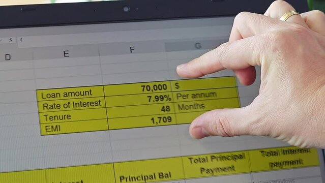 Footage of the man scrolling trough the screen showing excel sheet of the bank loan amortization table. Banking