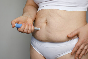 Injection Pen and Female Stomach. Semaglutide or Insulin Injection pen Diabetes Drug Being Used For...