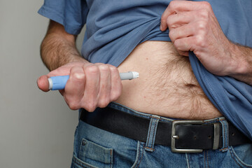 Man making Injection in her Stomach. Semaglutide or Insulin Injection Diabetes Drug