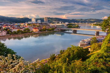Linz, Austria. Aerial cityscape image of riverside Linz, Austria during spring sunset with reflection of the city in Danube river.