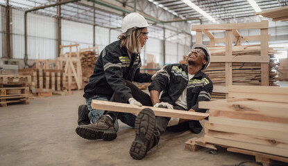 Multiracial foreman injured at leg from accident crying with pain in warehouse. Female engineer...