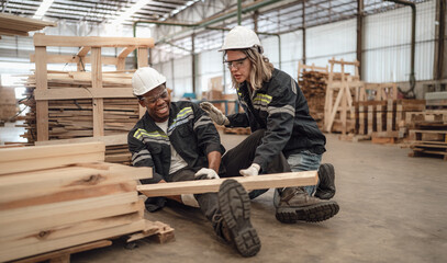 Multiracial foreman injured at leg from accident crying with pain in warehouse. Female engineer emergency help colleague who falling down get physical injury in factory. Diverse people in workplace.